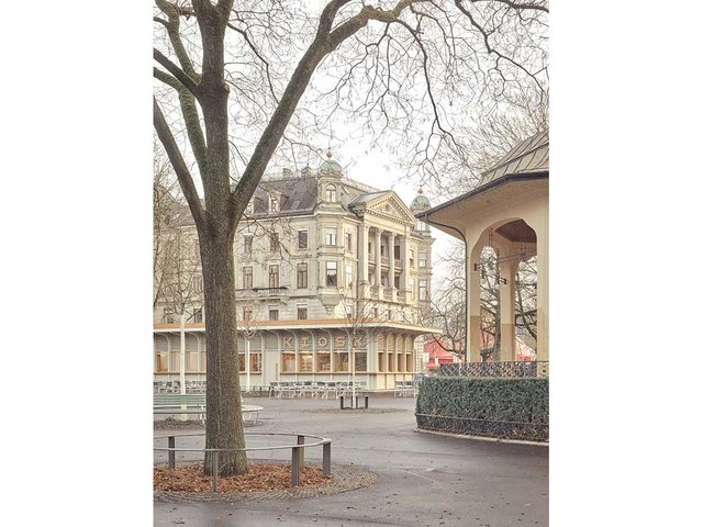 In seiner Gestaltung korrespondiert der Kiosk sensibel mit den historischen Nachbargebäuden. Im Hintergrund eines der Prachtgebäude am Stadthausquai, rechts der Musikpavillon (1908).