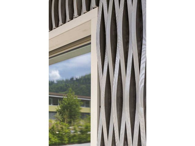 Die CNC-gefräste Lattung in gegenläufiger Wellenform bringt Bewegung in die Fassade. Das verwendete Weisstannenholz stammt aus der Region. 