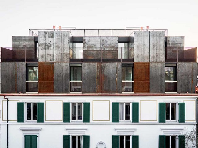 Die mit Stahlplatten und Streckmetall verkleidete Fassade (strassenseitig) nimmt die Symmetrie des darunterliegenden Bestandsgebäudes auf. Auf der Rückseite des Gebäudes ist die Fassade hingegen nicht symmetrisch. 