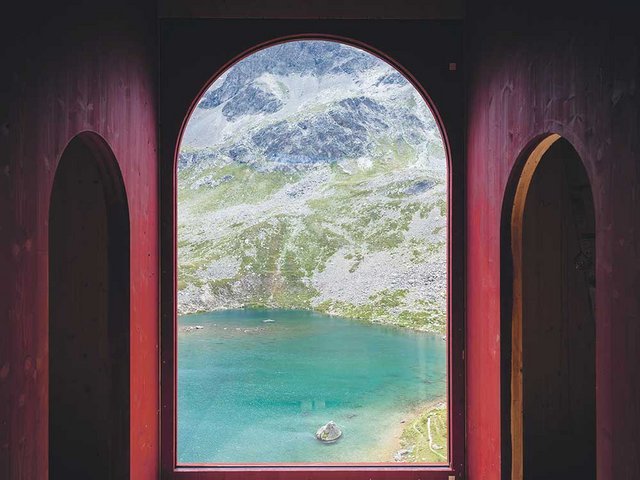 Hohe Bogenfenster lassen das bündnerische Alpenpanorama Teil des Theaterraums werden. 
