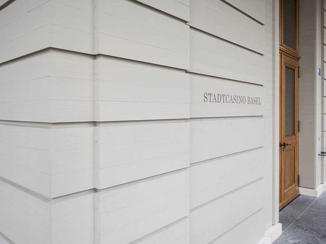 Nur ganz aus der Nähe ist der Fassade das Holz anzusehen. Um die Steinprofile zu imitieren, wurde Accoya ausgewählt, ein modifiziertes Holz, das wenig schwindet und quillt.