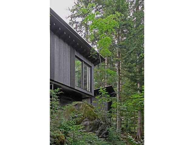 Mit drei kleinen Holzbauten mitten im Wald wurde das Hotel am Blausee (BE) erweitert. Die Häuser wurden naturschonend in das Gelände eingepasst.
