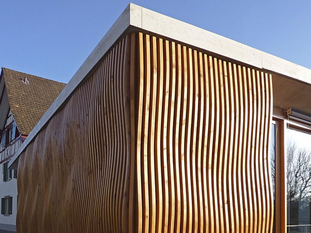 Puristischer Anbau für ein historisches Riegelhaus. Die nackten Boden- und Deckenplatten aus Beton kontrastieren 