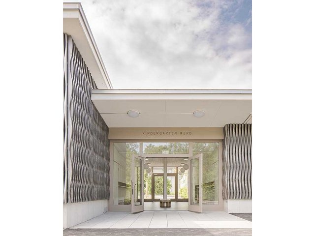 Der Eingangsbereich mit Garderobe befindet sich zwischen den beiden Klassentrakten, die rechts und links daran anschliessen.