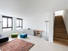 Die Wohnungstreppen sind bauphysikalische Multitalente. Ihre Trittschalen aus Eiche liefern den einzigen sichtbaren Hinweis auf den Holzbau.
